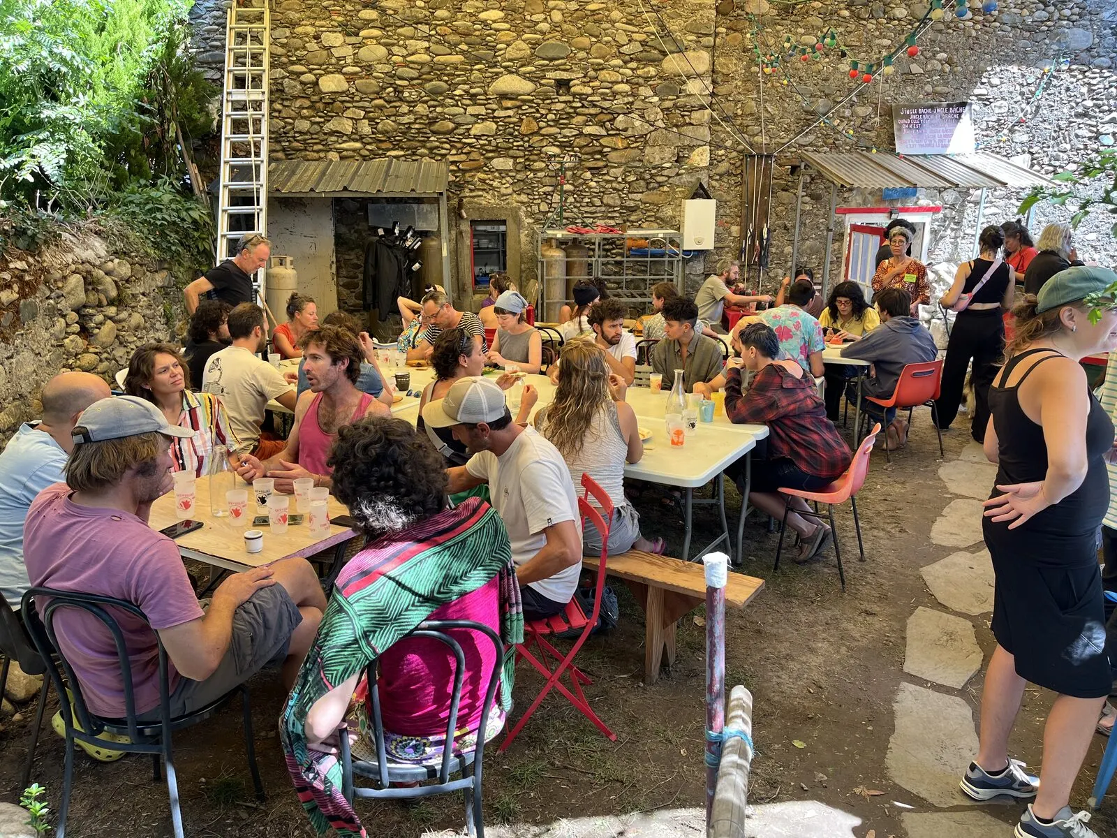 Le jardin du Café rempli de tables et de convives, un midi de fête